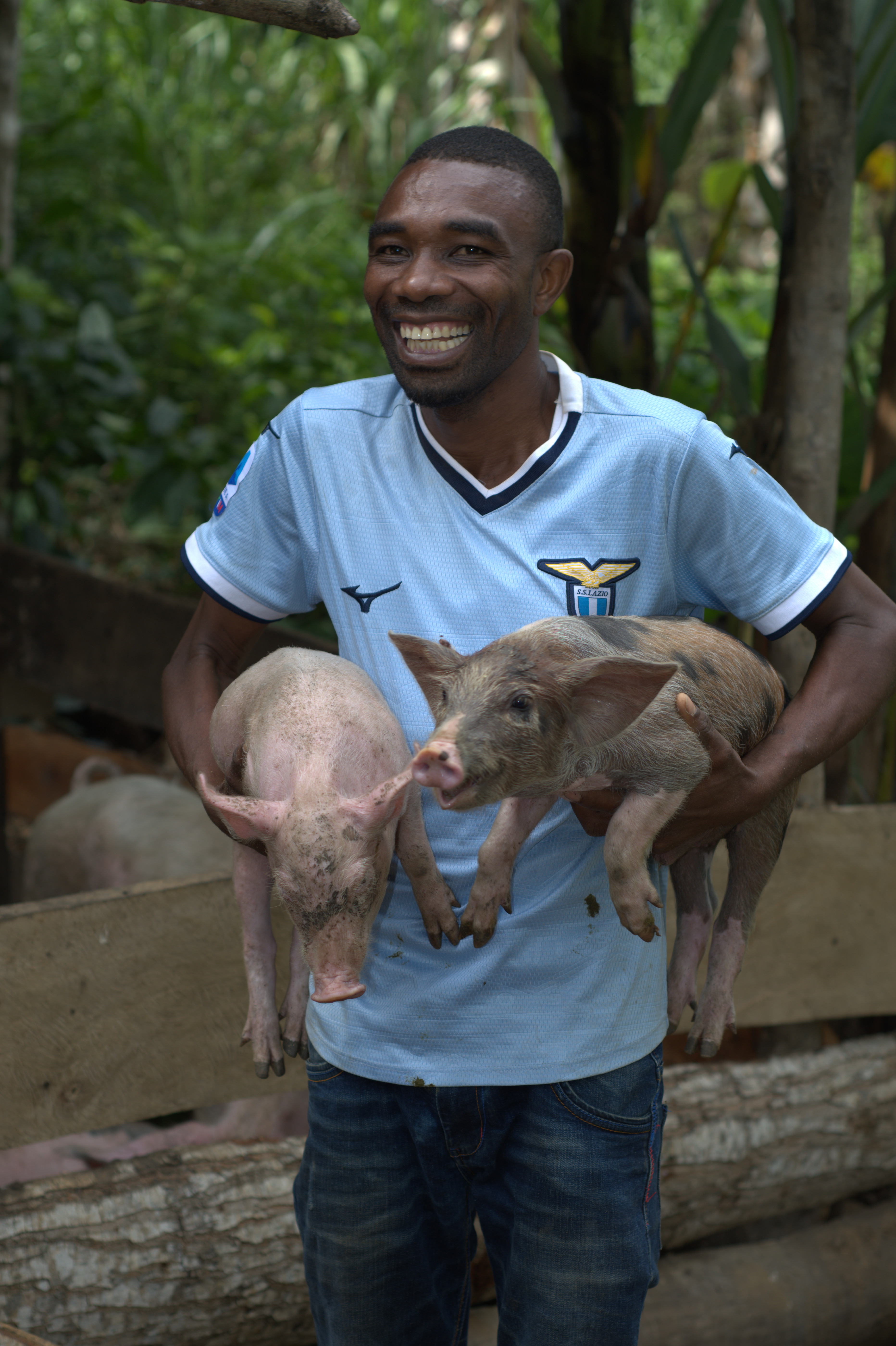 Theodory Mkude holding some of the chickens on his farm, which he purchased after selling beans through the Baridi Sokoni Project. Photo: ESAFF