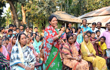 Women wearing traditional clothes at an outdoors meeting in Rangpur, Bangladesh
